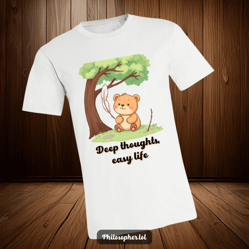 Funny happy bear sits under a tree, pondering a floating feather, a serene t-shirt for moments of reflection.